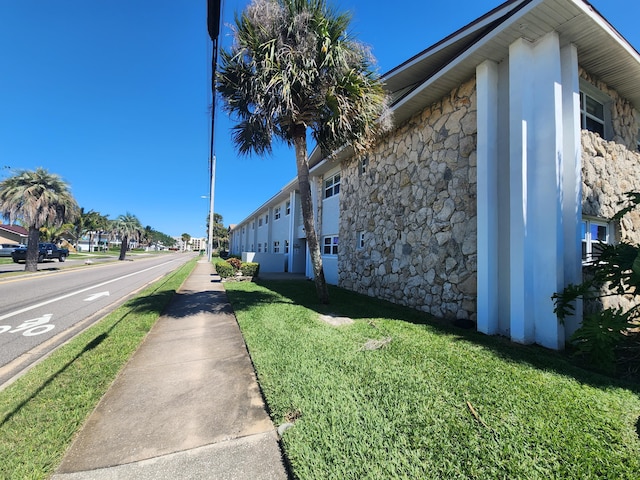 view of property exterior featuring a lawn and stone siding