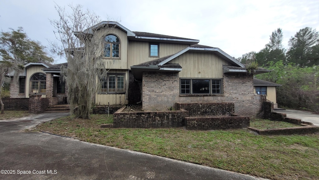 view of front of home with brick siding and a front yard