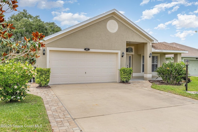 3873 San Miguel Ln, Rockledge, FL 32955 - view of front of home with stucco siding, concrete driveway, a garage, and roof with shingles