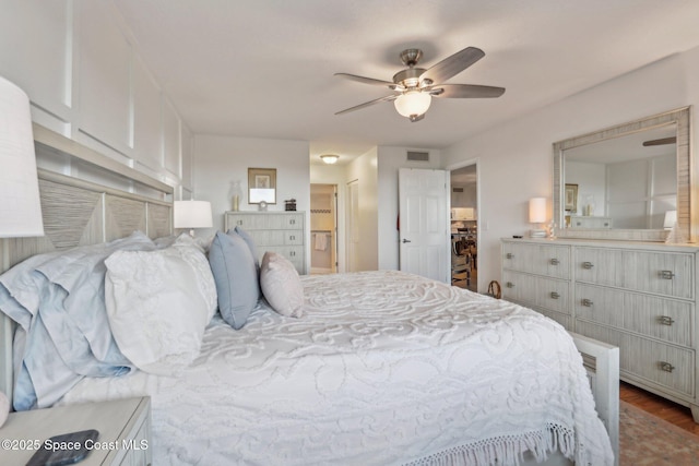 bedroom featuring wood finished floors, ensuite bath, and ceiling fan