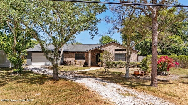 512 Palmetto Dr, Melbourne, FL 32935 - ranch-style home with brick siding, a front lawn, and gravel driveway