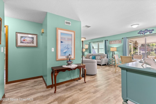 550 E Merrimac Dr, Merritt Island, FL 32952 - living area featuring a textured ceiling, visible vents, and light wood-style floors