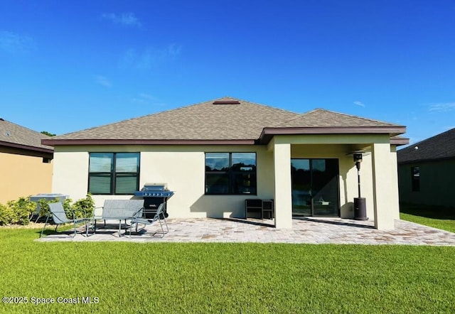 back of house featuring a lawn, a patio, stucco siding, and a shingled roof