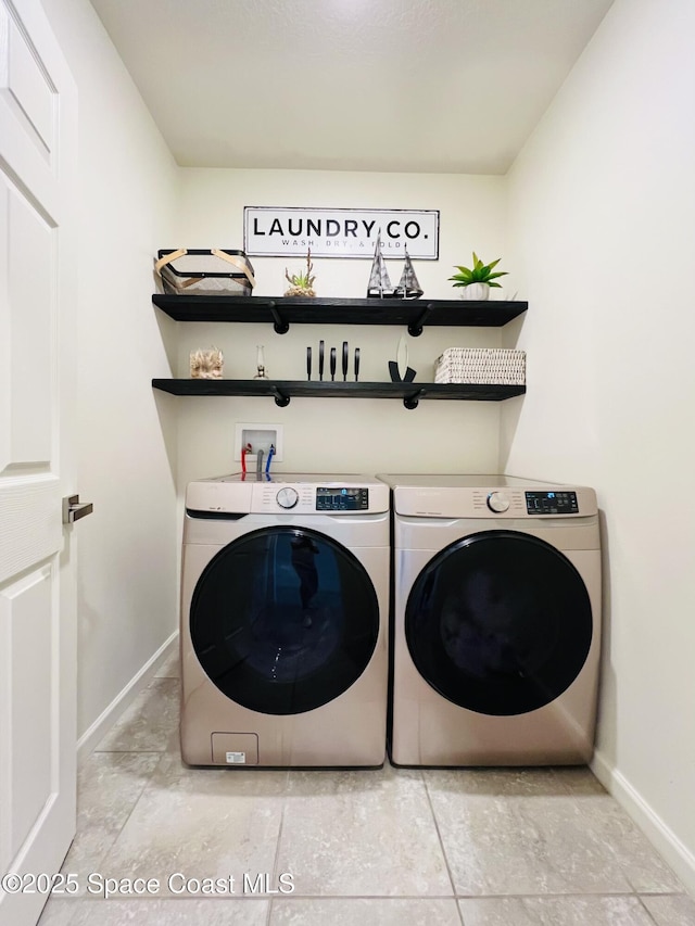 washroom with baseboards, laundry area, and washer and clothes dryer