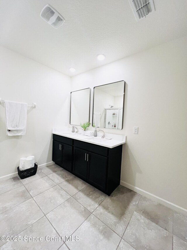 full bathroom with double vanity, baseboards, tile patterned flooring, and visible vents