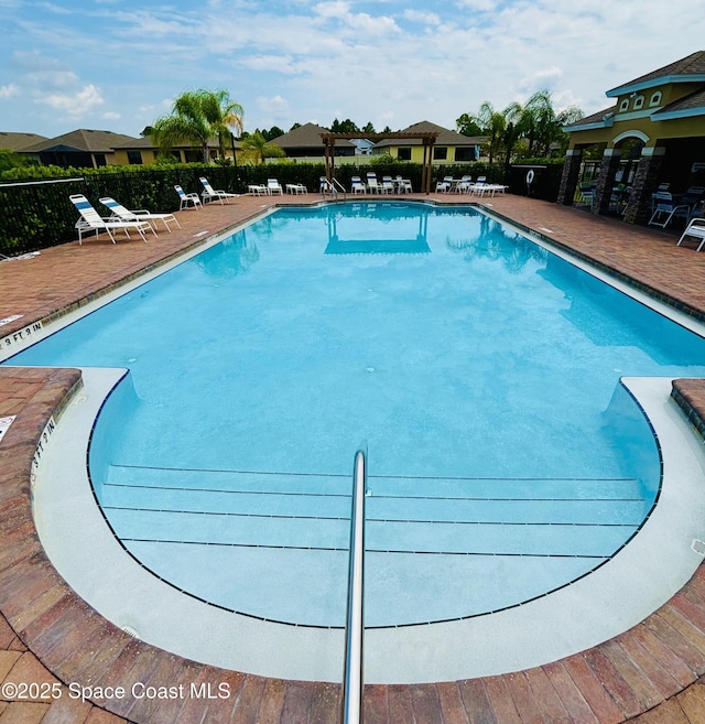 community pool featuring fence and a patio area
