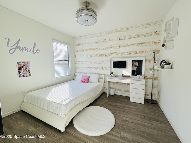 bedroom featuring baseboards and wood finished floors
