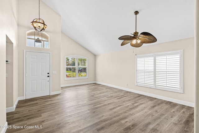 1050 Olde Bailey Ln, Melbourne, FL 32904 - foyer with a ceiling fan, a chandelier, wood finished floors, high vaulted ceiling, and baseboards
