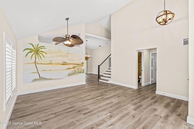 1050 Olde Bailey Ln, Melbourne, FL 32904 - empty room with stairway, high vaulted ceiling, ceiling fan, wood finished floors, and baseboards
