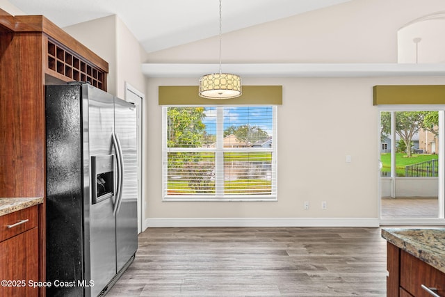 1050 Olde Bailey Ln, Melbourne, FL 32904 - kitchen featuring stainless steel fridge with ice dispenser, vaulted ceiling, wood finished floors, decorative light fixtures, and baseboards