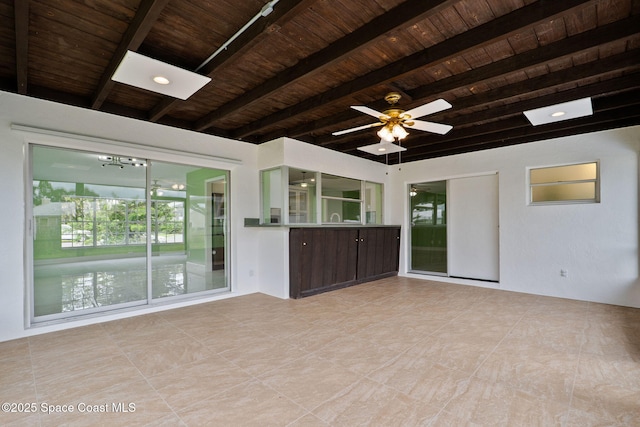 unfurnished living room featuring wood ceiling, beam ceiling, a chandelier, and a ceiling fan