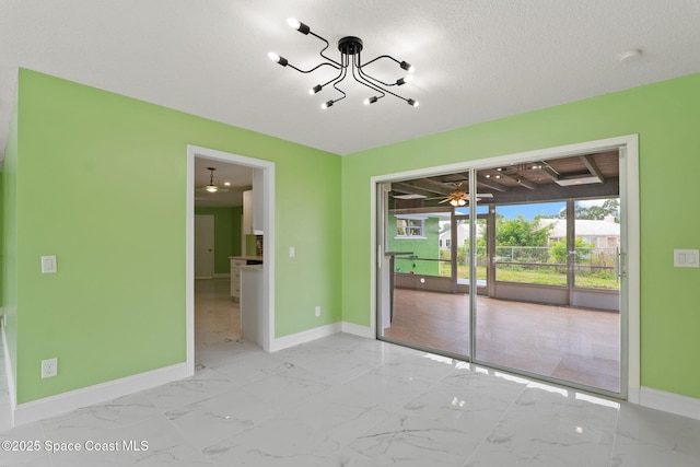spare room featuring baseboards, marble finish floors, and a chandelier