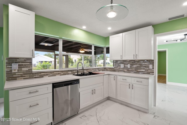 kitchen featuring dishwasher, a sink, decorative backsplash, white cabinetry, and light marble finish floors