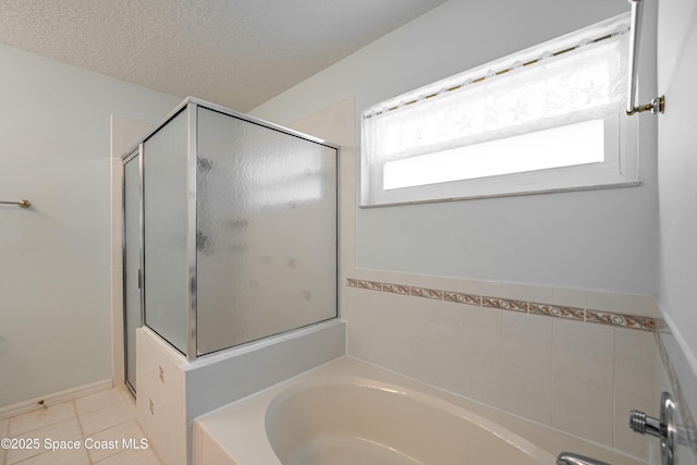 bathroom featuring a textured ceiling, tile patterned flooring, a shower stall, and a bath