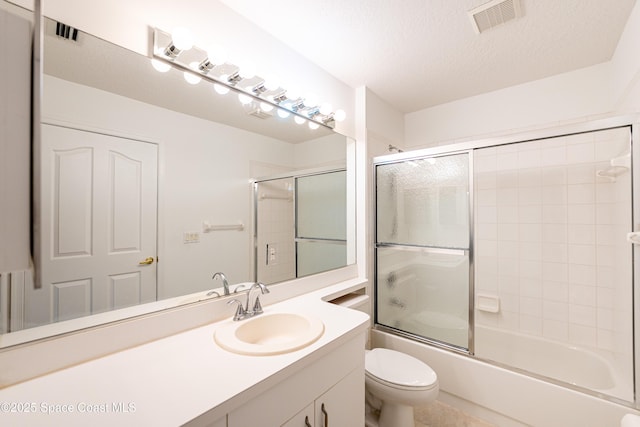 full bath featuring visible vents, vanity, toilet, bath / shower combo with glass door, and a textured ceiling