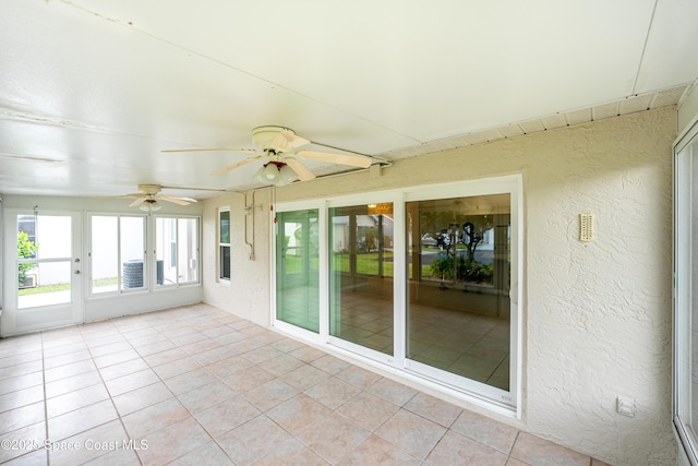 unfurnished sunroom with ceiling fan and french doors
