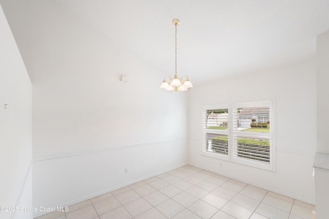 empty room featuring an inviting chandelier, baseboards, lofted ceiling, and light tile patterned floors
