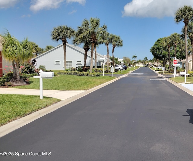 view of street featuring traffic signs, curbs, and a residential view