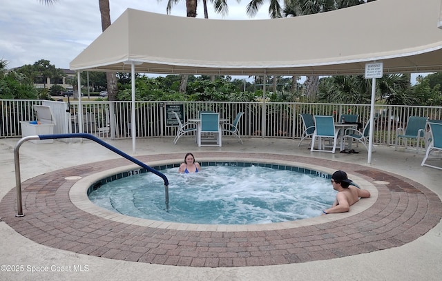 view of pool with fence, a patio, outdoor dining area, and a hot tub