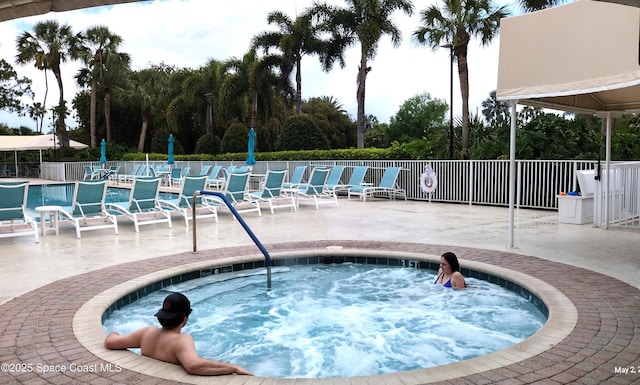 view of pool featuring fence, a hot tub, and a patio area