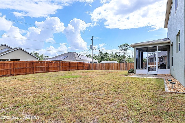 view of yard featuring a sunroom and a fenced backyard