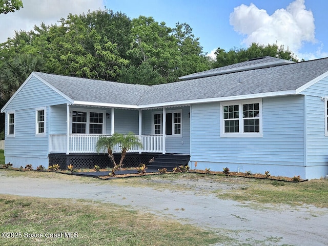 ranch-style home featuring roof with shingles and a porch