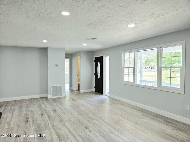 unfurnished living room featuring visible vents, recessed lighting, baseboards, and wood finished floors
