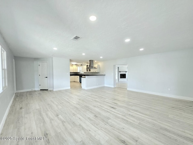 unfurnished living room with recessed lighting, baseboards, visible vents, and light wood-type flooring