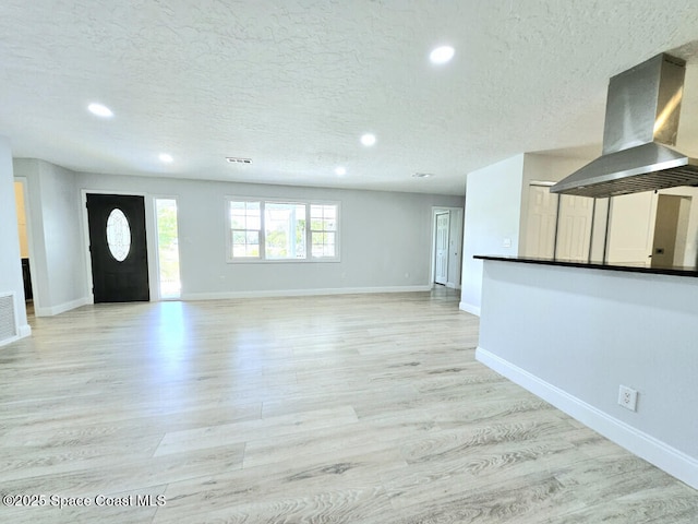 unfurnished living room with baseboards, recessed lighting, and a textured ceiling