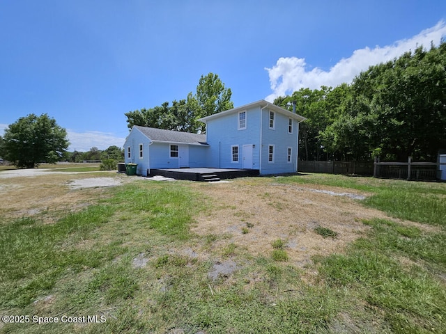 back of house with fence and a lawn