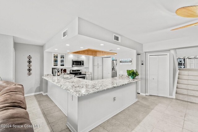 2207 Atlantic St Unit 825, Melbourne Beach, FL 32951 - kitchen featuring a peninsula, stainless steel appliances, glass insert cabinets, and visible vents