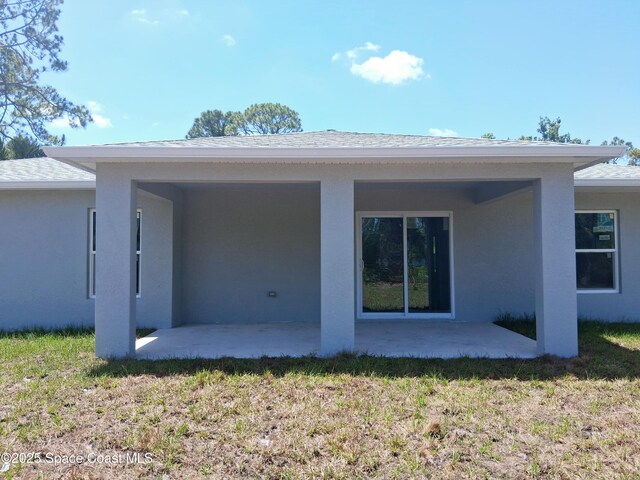 411 La Coco St SW, Palm Bay, FL 32908 - back of property featuring a patio, stucco siding, and a yard
