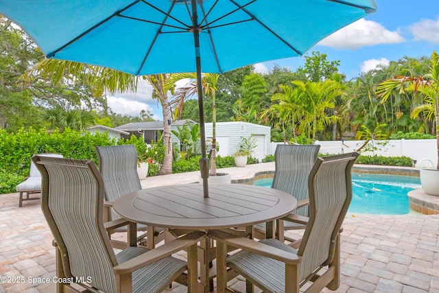 view of patio / terrace with outdoor dining area, fence, and a fenced in pool