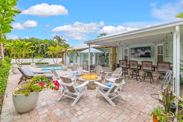 view of patio with fence, a fenced in pool, and a fire pit