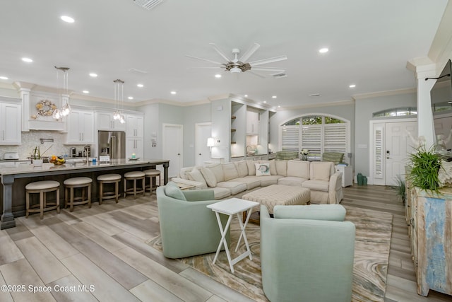living room featuring a ceiling fan, recessed lighting, visible vents, crown molding, and light wood-style floors