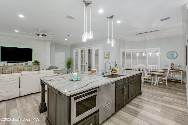 kitchen with stainless steel dishwasher, crown molding, visible vents, and a sink