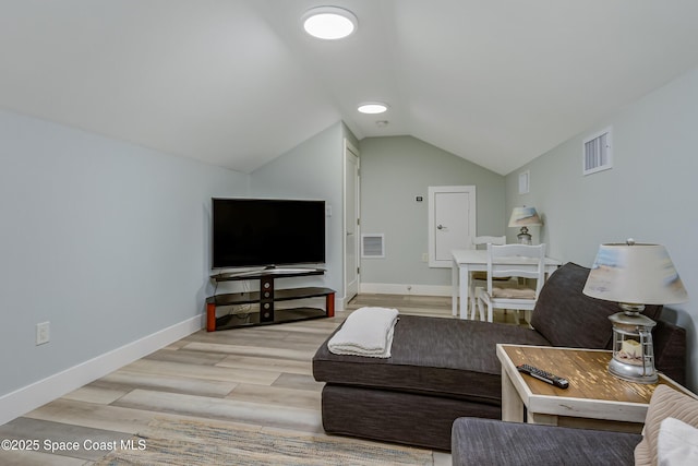 living area featuring baseboards, wood finished floors, visible vents, and vaulted ceiling
