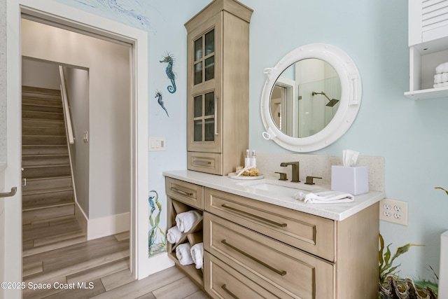 bathroom with baseboards, wood finished floors, and vanity