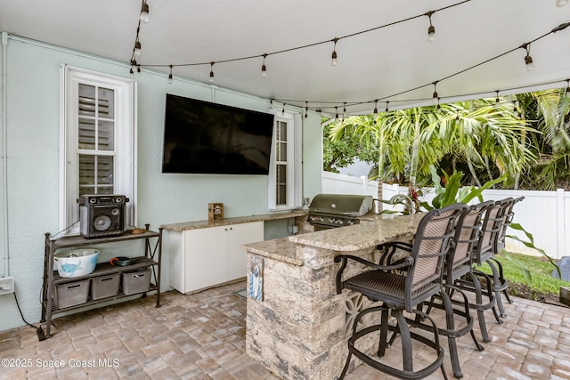 view of patio / terrace with area for grilling, outdoor wet bar, and fence