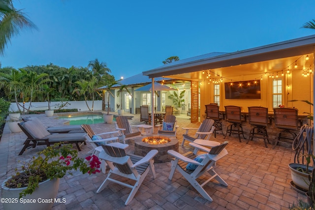 view of patio featuring an outdoor fire pit, a fenced in pool, and a fenced backyard