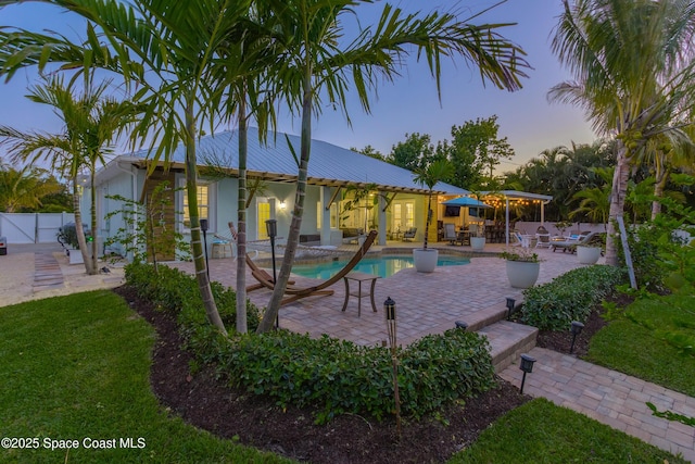 exterior space featuring outdoor dining area, fence, a patio, and a fenced in pool