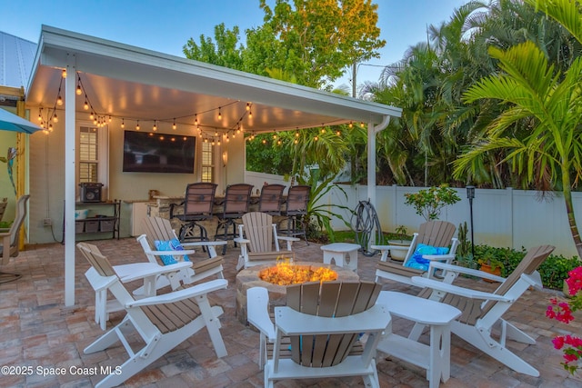 view of patio with an outdoor fire pit and fence