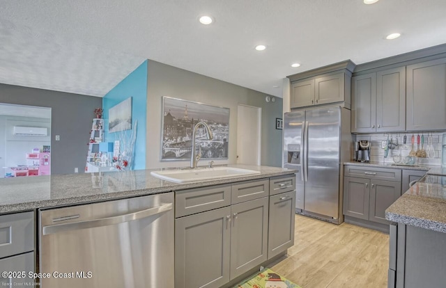 kitchen featuring recessed lighting, gray cabinetry, appliances with stainless steel finishes, and a sink
