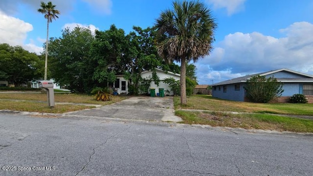 view of front facade featuring driveway and a front yard