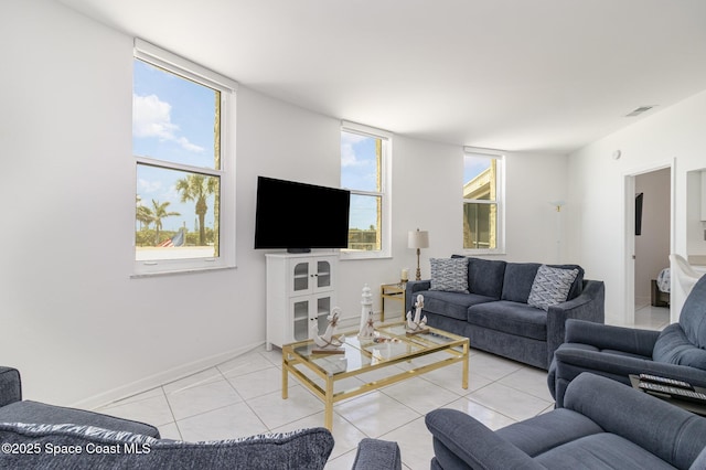 living room with baseboards, tile patterned floors, a healthy amount of sunlight, and visible vents