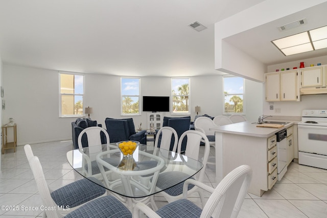 dining space with light tile patterned floors, a healthy amount of sunlight, and visible vents