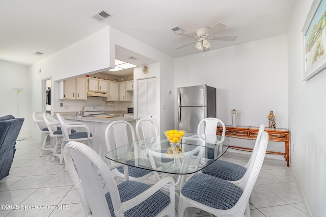 dining room with baseboards, a ceiling fan, and visible vents