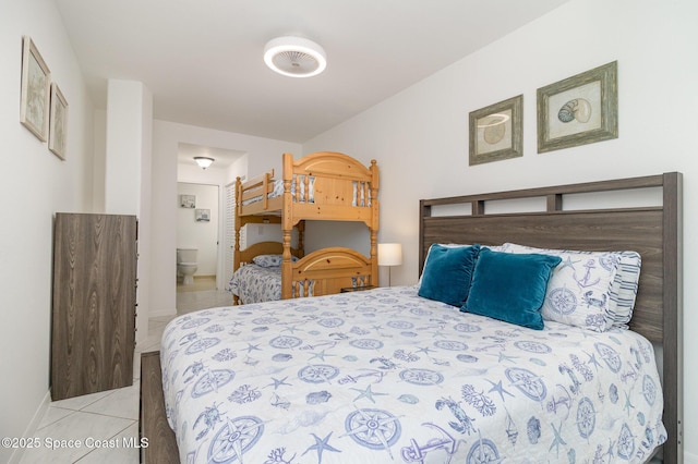 bedroom with light tile patterned floors and ensuite bathroom