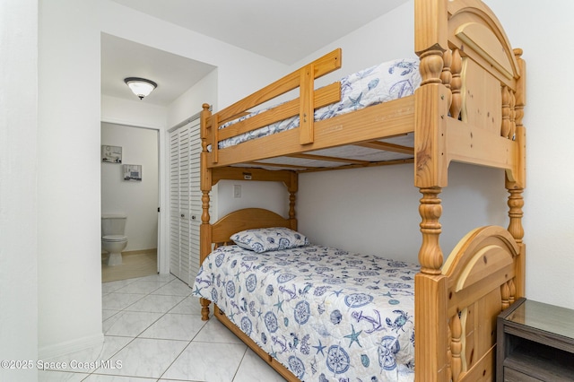 bedroom featuring light tile patterned floors and ensuite bathroom
