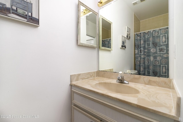 bathroom with curtained shower, visible vents, and vanity